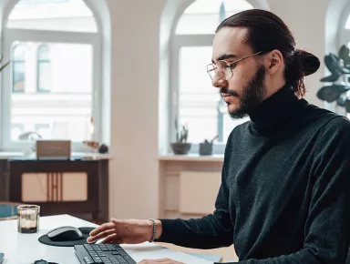 Un chargé d'études média devant un ordinateur au bureau