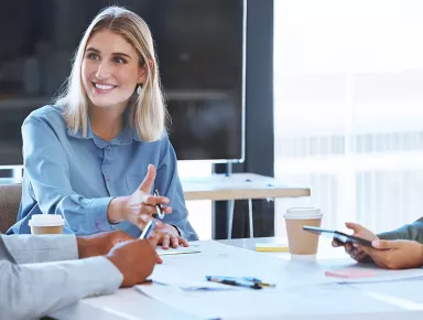 Responsable de la communication effectuant une présentation face à deux collègues