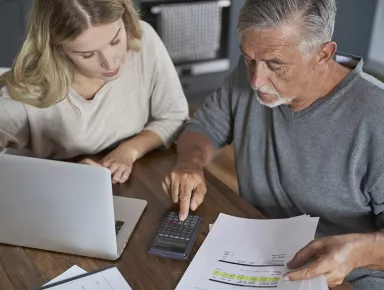 An elderly man working with his adult daughter