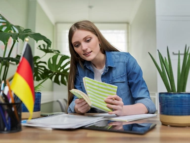 Etudiante ouvrant un carnet près d'un drapeau allemand