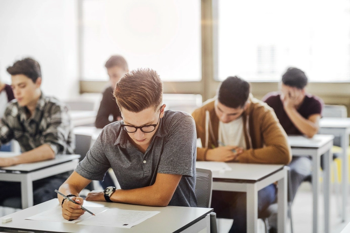 Etudiants dans une classe et écrivant sur des copies