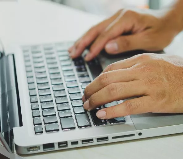 Hands typing on a computer keyboard